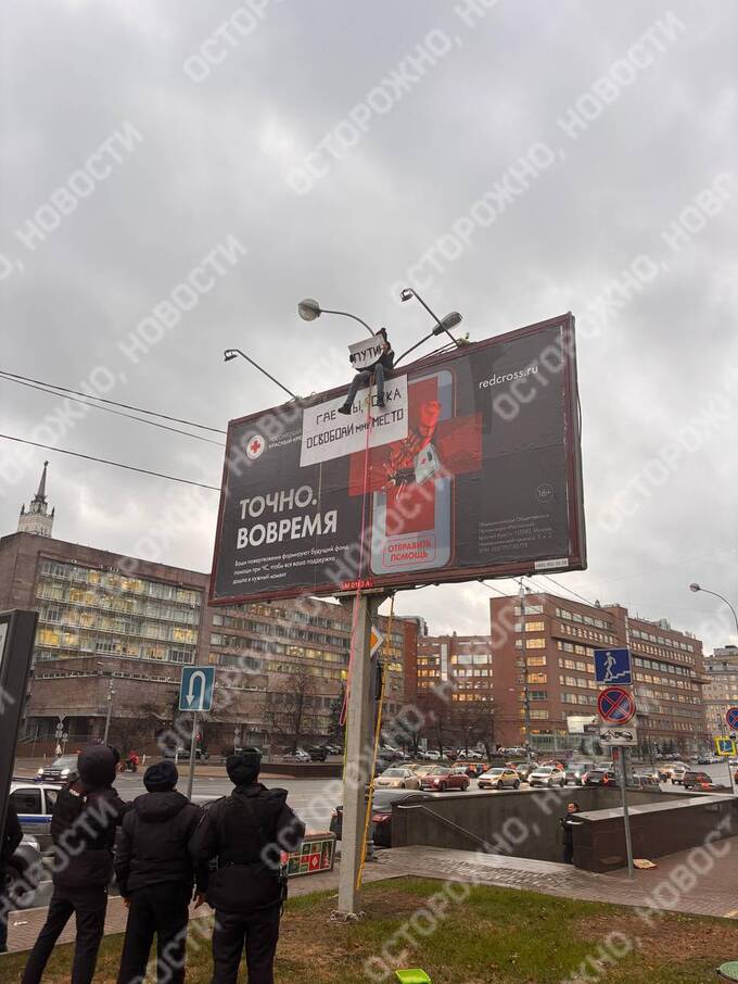 Мужчина с провокационным плакатом про Путина забрался на билборд в центре Москвы